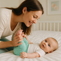 Baby trägt Baby Corner Babyhose in Mint auf dem Bett mit Mama – anschmiegsame Baumwolle, komfortabler Sitz; perfektes Basic für den Alltag und die Babyerstausstattung (Größen 56–62 und 62–68 cm).
