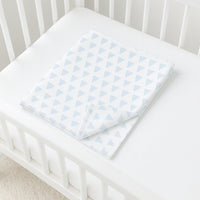 Julius Zöllner Jersey-Babydecke mit hellblauem Dreieckmuster gefaltet im weißen Gitterbett – 100 % Baumwolle, Oeko-Tex Klasse 1, ideal für Kinderwagen/Wiege.