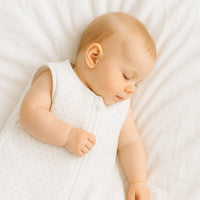 Baby schläft im Julius Zöllner Babyschlafsack, weiß mit Punkt-Print, Größe 70 cm – sicherer, warmer Schlaf im Bettchen.