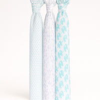 Drei Musselin Swaddle-Tücher von Julius Zöllner, 120×120 cm, weiß/mint mit Punkt-, Dreieck- und Elefanten-Print, nebeneinander aufgehängt.