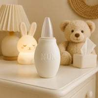 NUK Nasensauger in weiß auf der Wickelkommode im Babyzimmer – hygienischer, BPA-freier Nasenreiniger für Neugeborene und Säuglinge, ideal für die Baby Box und unterwegs.