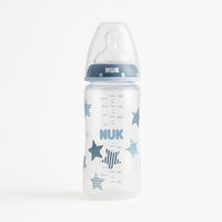 NUK Babyflasche 300 ml mit blauem Schraubring und Sternen-Dekor; Polypropylen BPA-frei, First Choice+ System, Silikon-Trinksauger Größe M 0–6 Monate für Milchnahrung; klare Skala, auslaufsicher – perfekte Babyflasche für die Erstausstattung und als Geschenk.