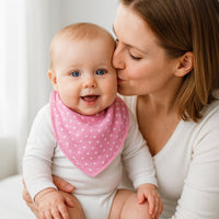 Baby auf dem Arm trägt Pippi Babyhalstuch in old rose (altrosa) mit weißen Punkten – weiches, saugfähiges Dreieckstuch mit Druckknopf, One Size; praktischer Begleiter beim Sabbern und Füttern, schönes Geburtsgeschenk.