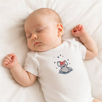 Weißer Sanetta Kurzarmbody mit Bären-Print an schlafendem Baby im Bett; weiche Bio-Baumwolle, hautfreundlich und GOTS zertifiziert, pflegeleicht und trocknergeeignet.