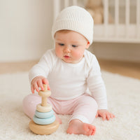Baby sitzt in rosa Bio-Hose von Sense Organics (62–68 cm), GOTS-Feinripp – kuscheliger Begleiter, süße Idee als Geschenk zur Geburt.
